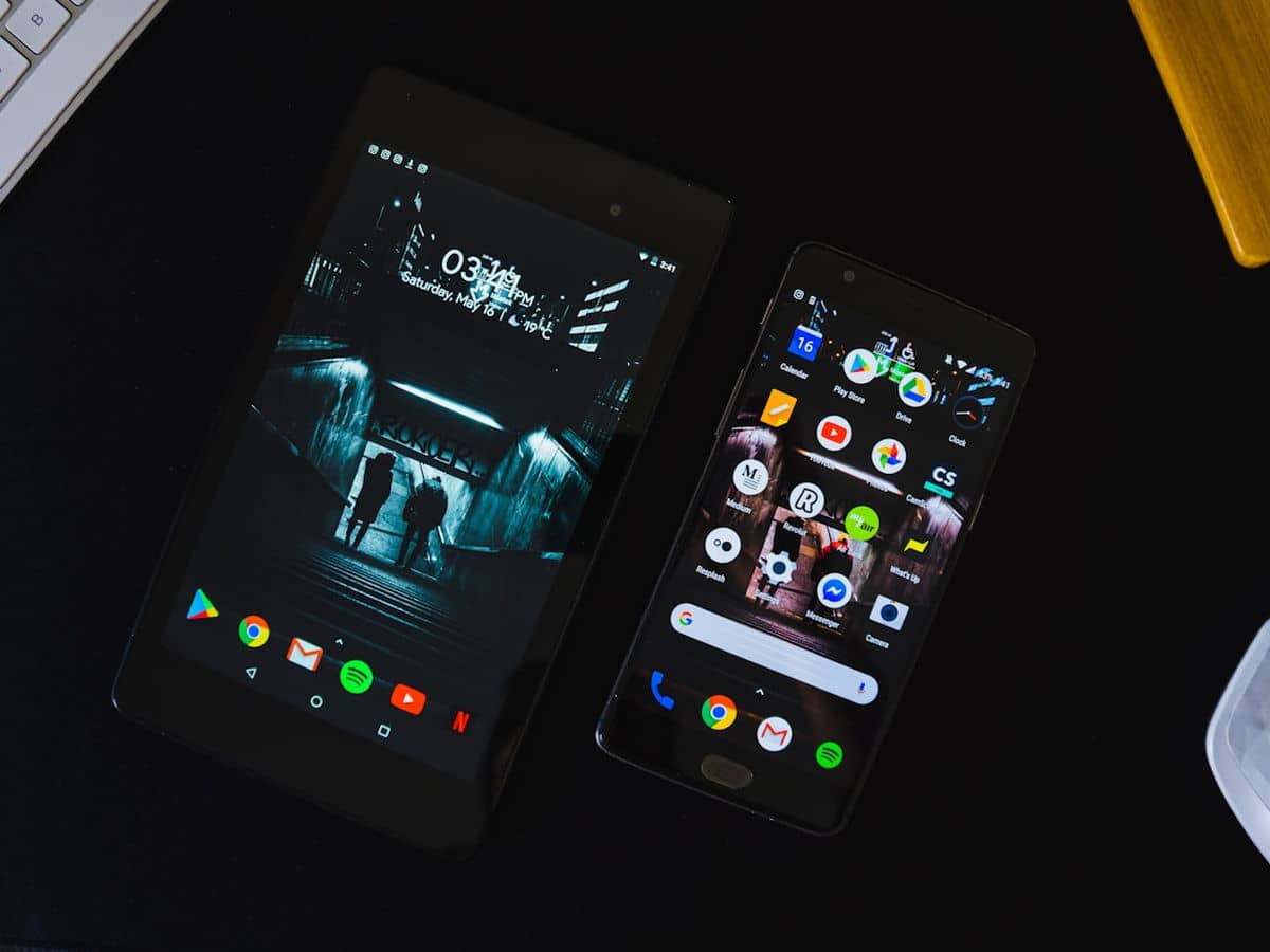 Dois smartphones exibindo interfaces de aplicativo sobre fundo escuro