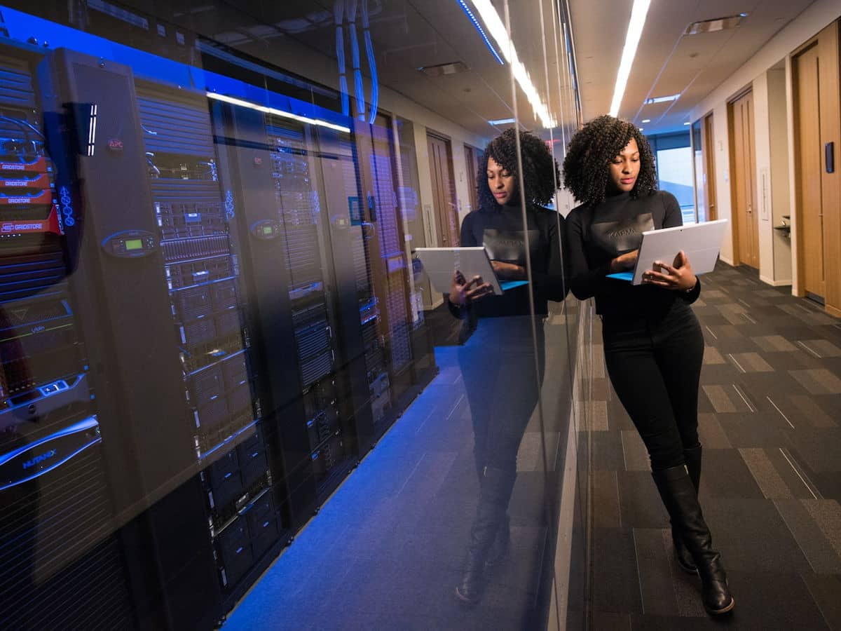 Profissional monitorando infraestrutura em um corredor de data center